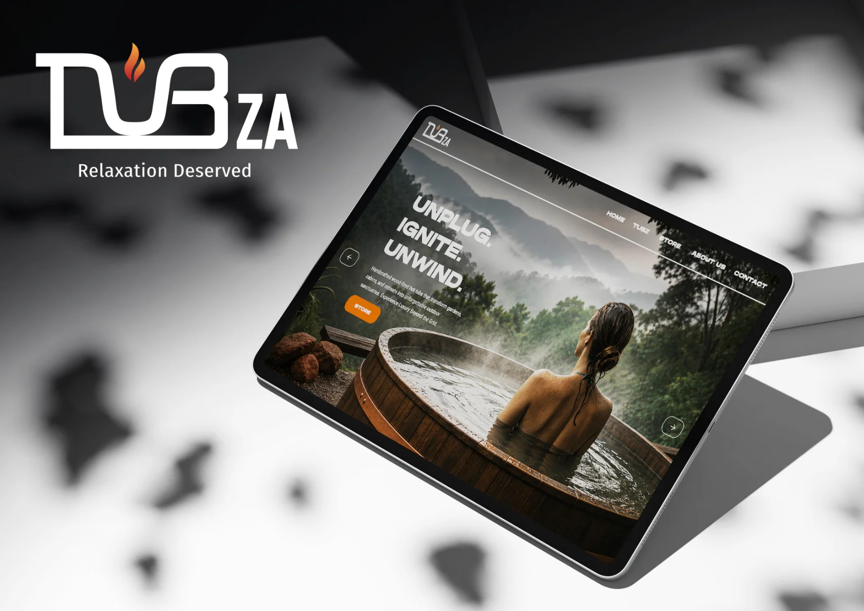 TubZA logo with the tagline Relaxation Deserved, beside a tablet previewing the new TubZA website: a woman relaxing in a steaming wood-fired hot tub overlooking misty forest mountains.